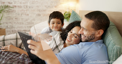 Image of Family, bed and watching on tablet with a smile and cartoon with mom, dad and kid together. Bedroom, tech and education children program with mother, father and young boy with a youth movie at home