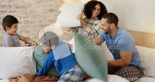 Image of Happy family, pillow fight and bedroom with kids, playing and excited with love, bonding and care in home. Man, woman and boy children on bed for game, playful conflict or comic quality time in house