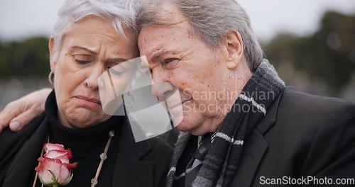 Image of Funeral, graveyard and senior couple hug for comfort, empathy and support at memorial service. Depression, grief and sad man and woman embrace with flower for goodbye, mourning and burial for death