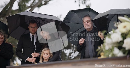 Image of Death, funeral and umbrella, people at coffin for service in graveyard in respect, mourning and support. Flowers, rain and loss, family at casket in cemetery with memory, grief and grave for burial.