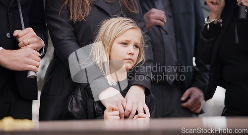 Image of Child, sad and family at funeral at graveyard ceremony outdoor at burial place. Death, grief and group of people with casket or coffin at cemetery for service while mourning a loss at event or grave