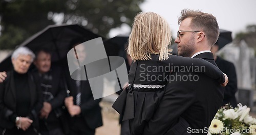 Image of Sad, hug and a father and child at a grave for a funeral and mourning with a group of people. Holding, young and a dad with care and love for a girl kid at a cemetery burial and grieving together