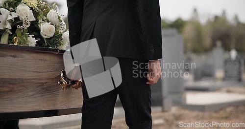 Image of Coffin, hands and man walking at funeral ceremony outdoor with pallbearers at tomb. Death, grief and person carrying casket at cemetery, graveyard or family service of people mourning at windy event