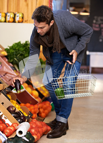Image of Healthy food, search and man shopping at a supermarket for grocery promotions, sale or discounts deal. Check, fresh or customer buying groceries for fruits, organic vegetables or eggplant with choice