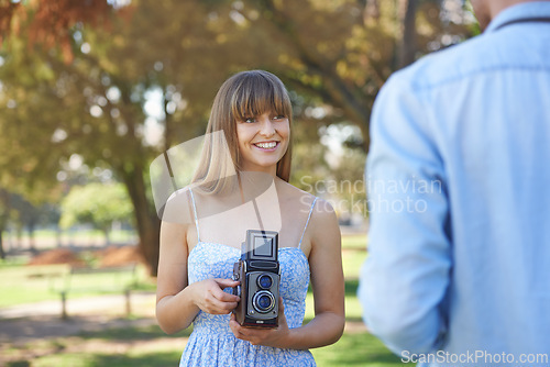 Image of Couple, park or happy woman with vintage camera for outdoor photography, photo memory or tourism. Retro equipment, creative photoshoot or photographer shooting boyfriend for garden picture in nature