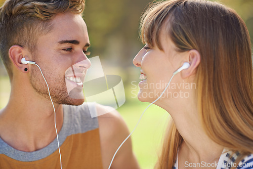 Image of Outdoor, couple and listening to music with earphones in garden, park or relax in summer with technology. Happy, man and woman hearing radio, audio or streaming podcast together with love in nature