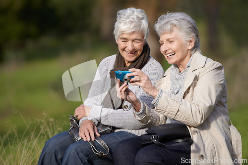 Image of Senior woman, outdoor and camera with pictures, happy and photography with memories in nature or elderly. Technology, bonding and chatting with friend, funny and laughing together in retirement