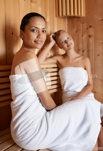 Image of Sauna, portrait and friends relax in spa for skincare, healthy detox or sweat for beauty wellness. Luxury, treatment and women sitting with towel in steam room for calm, skin care or benefits to body