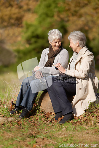 Image of Senior women, laughing or conversation in nature for travel, together or bonding on retirement in outdoor. Elderly friends, smile or communication on vacation in countryside, care or social on rock
