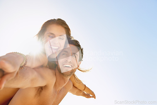 Image of Happy couple, piggyback and support with blue sky at beach for love, care or enjoying outdoor holiday or weekend. Face of man and woman smile for fun embrace, trust or hug in summer on mockup space