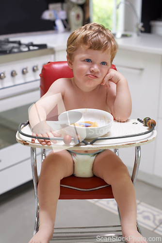 Image of Eating, toddler and boy in chair for food, feeding or meal in house kitchen or home for breakfast. Hungry kid, baby thinking and healthy child with bowl for nutrition, natural diet or growth alone