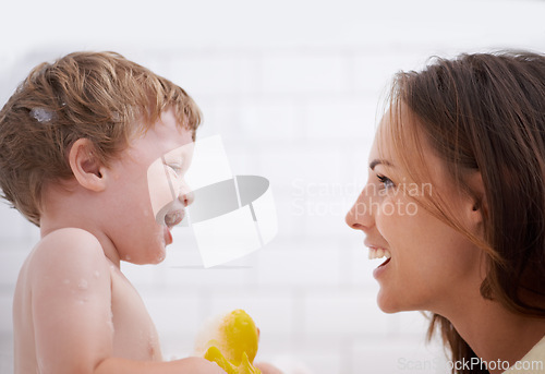 Image of Happy, rubber duck and mother bathing baby for hygiene, body care and health at family home. Smile, toy and young mom washing and bonding with infant, kid or child toddler in bathroom of house.