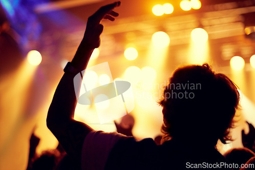 Image of Night, club and man dance at concert, event or music festival with stage lights and silhouette. Dark, nightclub and person in audience, crowd and social celebration at techno rave with energy