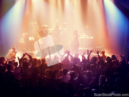 Image of Concert, band and music with hands from people at dj, club and festival event at a stage with lights. Rock show, dance and party with excited crowd with rave, techno and entertainment at venue