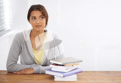 Image of Woman, student or thinking with books by desk, idea or learning for research of assignment. Young person, indian and thought by notebook on scholarship, studies and planning for test study in college