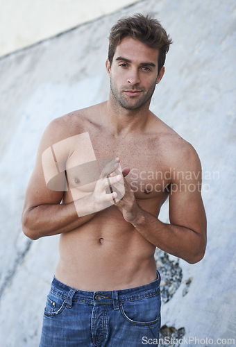 Image of Man, portrait and fitness body with abs, stomach and wellness outdoor by a wall. Summer, workout and fashion of a male person from Brazil with strong arms, torso and topless with confidence and smirk