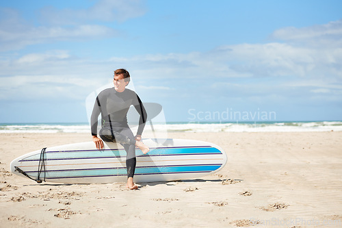 Image of Surfing, relax and man with surfboard on beach for water sports training, exercise and fitness outdoors. Nature, happy and person with blue sky for adventure on holiday, vacation and hobby by ocean