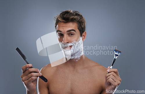 Image of Man, portrait and shaving choice with cream in studio for razor, modern or retro grooming by grey background. Person, model and decision with beard, facial hair removal or product for cosmetic change