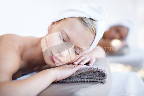 Image of Woman, relax and lying on bed in spa for skincare, beauty and luxury treatment for wellness. People, rest and face of calm person on table in hotel for massage or dermatology care with peace and zen