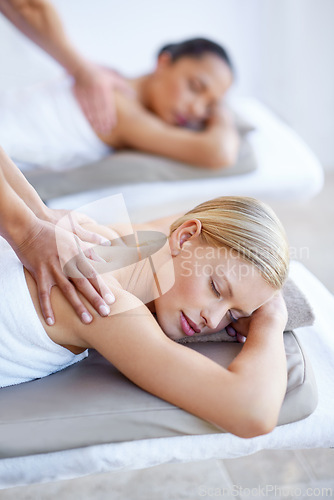 Image of Back, massage and women relax in spa for skincare, beauty and luxury treatment for wellness and peace. People, rest and hands on person in hotel, salon or on bed for dermatology care of body