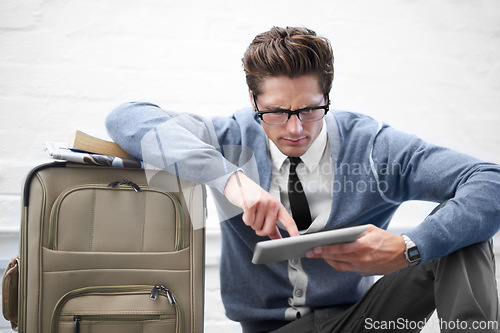 Image of Business man, reading or baggage with tablet, floor and stress with app, flight or travel by wall background. Entrepreneur, person or touchscreen on social media, bag or check booking for immigration