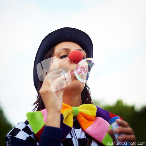 Image of Clown blowing bubbles at outdoor festival for fun, fantasy and summer adventure in nature. Face of person, street performer or circus character in park with creative color at happy carnival event.