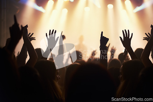 Image of Hands, crowd and solidarity or music festival at night, collaboration and energy at nightclub. People, closeup and celebration at party or social event, concert and community for band performance