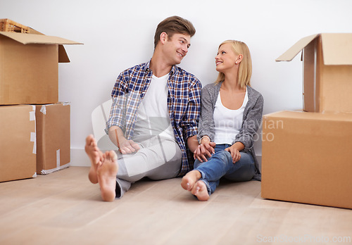Image of Couple, moving and new home with boxes for packing, real estate and happy holding hands for support. Property, achievement or investment with people and cardboard for relocation, mortgage or rent