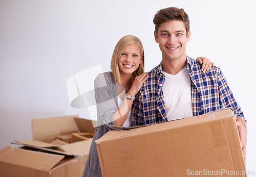 Image of Couple, moving and new home with box for packing, happy with real estate and support with smile in portrait. Property, investment and people with cardboard package for relocation, mortgage or rent