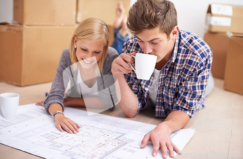 Image of Couple, floor plan and blueprints with moving boxes for renovation, new home or property investment. Man, woman and happy thinking or development for real estate design for mortgage, buy or coffee