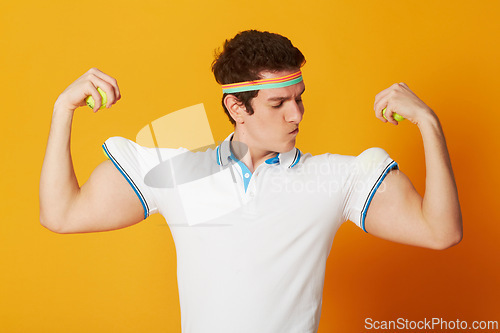 Image of Tennis, sports and man flexing arms with fitness and workout on yellow background. Person, model and athlete with wellness, goofy or funny with confidence and proud with health, strong or competitive