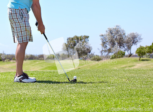 Image of Man, golf club and ball on green grass, field or lawn for sports, shot or ready to strike on course. Closeup of male person, golfer or player legs in stance with stick for score or point in nature