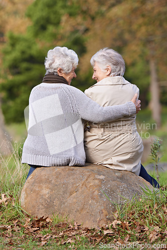 Image of Senior women, love and support by outdoor in nature, together and bonding on retirement on holiday. Elderly friends, smile and discussion on vacation in countryside, back and social with care on rock