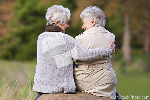 Image of Senior friends, hug and support by outdoor in nature, together and bonding on retirement on holiday. Elderly women, embrace or discussion on vacation in countryside, back or social with care on rock