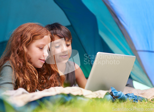 Image of Children, family and happy with laptop in tent for camping, social media and online movie with watching in nature. Friends, face and kids with smile outdoor on grass for gaming, relax and holiday fun