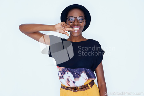 Image of Portrait, fashion and glasses with happy black woman in studio on white background for style. Model, smile and accessories with confident young hipster person biting finger in trendy clothes outfit