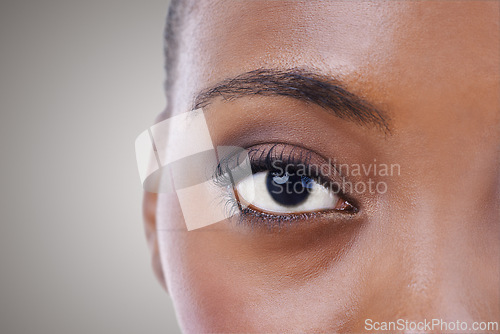 Image of Half, face and eye of black woman closeup for beauty or dermatology in gray background mockup. Skincare, portrait and African model with natural glow from makeup, cosmetics or facial in studio