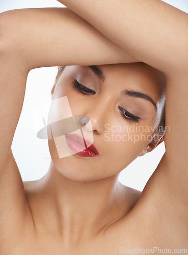 Image of Woman, face and beauty with red lipstick or makeup in cosmetics on a blue studio background. Closeup of young female person or model in relax or satisfaction for cosmetology or facial spa treatment