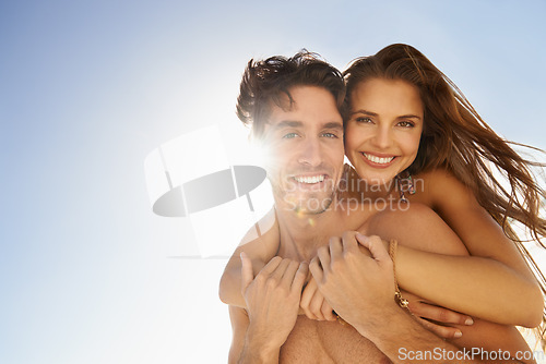 Image of Portrait, happy and couple in piggyback on beach for love, care or support on outdoor holiday weekend below blue sky. Face of man or woman smile for embrace, trust or hug in sunshine on mockup space