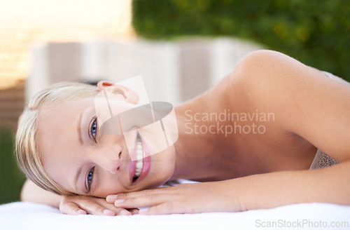 Image of Spa, woman and happy on massage bed with portrait for wellness, zen and beauty treatment for body care. Person, relax and physical therapy at resort, salon table and luxury on holiday or vacation