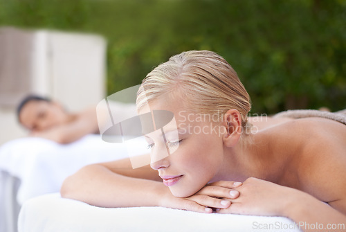 Image of Spa, woman and relax on massage bed with smile for wellness, zen and beauty treatment for body care. Person, sleeping and physical therapy at resort, salon table and luxury on holiday or vacation