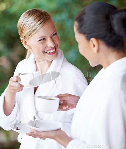 Image of Spa, friends and happy women drinking coffee for health, wellness and skincare treatment. Girls, tea cup and salon for beauty, luxury body therapy in bathrobe and diverse people relax together