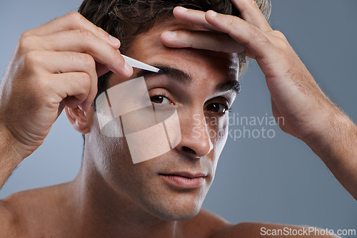 Image of Man, portrait and tweezers for eyebrows or pluck for face clean, hygiene or grey background. Male person, grooming and hair removal for healthy morning routine or studio, treatment or mockup space