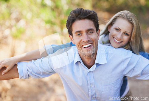 Image of Couple, portrait and smile in nature with love in relationship for holiday, vacation or travel. Romance, man and woman with happy outdoor in forest with embrace for bonding, care or relax in woods