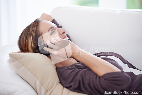 Image of Woman, laughing and relax on sofa for phone call, digital communication and mobile networking at home. Happy lady, cellphone or chat for audio contact, funny conversation or gossip on couch in lounge