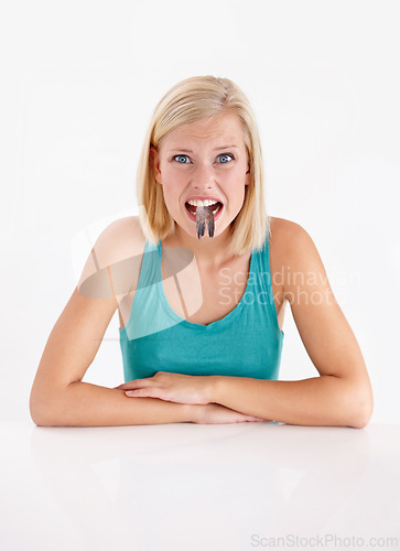 Image of Woman, portrait and eating a fish, tail or strange food in mouth on white background of studio. Crazy, diet and person with weird seafood, cuisine and face of disgust for taste of tuna or salmon