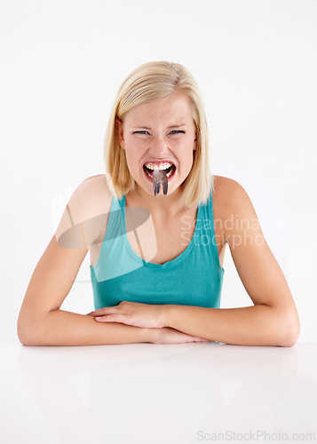 Image of Crazy, woman and portrait of eating fish, tail or strange food in mouth on white background of studio. Dislike, diet and person with weird seafood, cuisine and disgust for taste of tuna or salmon