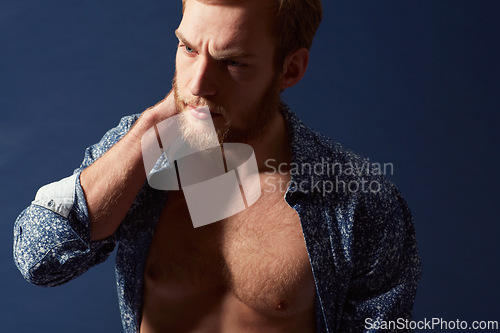 Image of Fashion, body or model with muscle in studio on a blue background wearing an open unbuttoned shirt. Thinking, chest or handsome male person posing on color wall for masculine style, health or fitness