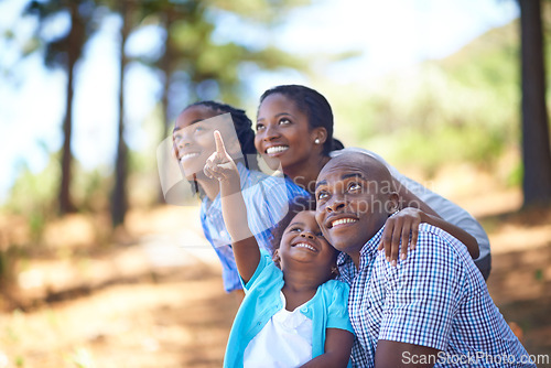 Image of Happy family, children and pointing in forest for bonding, adventure or outdoor holiday in nature. African mother, father and kids smile for fun day in support, love or weekend exploring in the woods