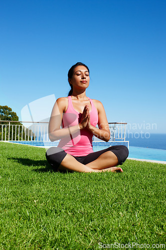 Image of Meditation, yoga and woman on grass praying for holistic balance, mindfulness and breathing exercise. Meditating, hands in prayer and person by ocean for wellness, health and zen energy outdoors